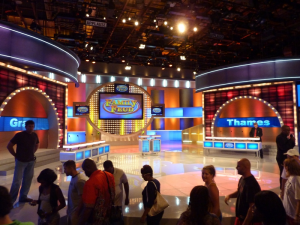 A staff member assists in directing the audience on the set of Family Feud. Image Credit: www.brianorndorf.com